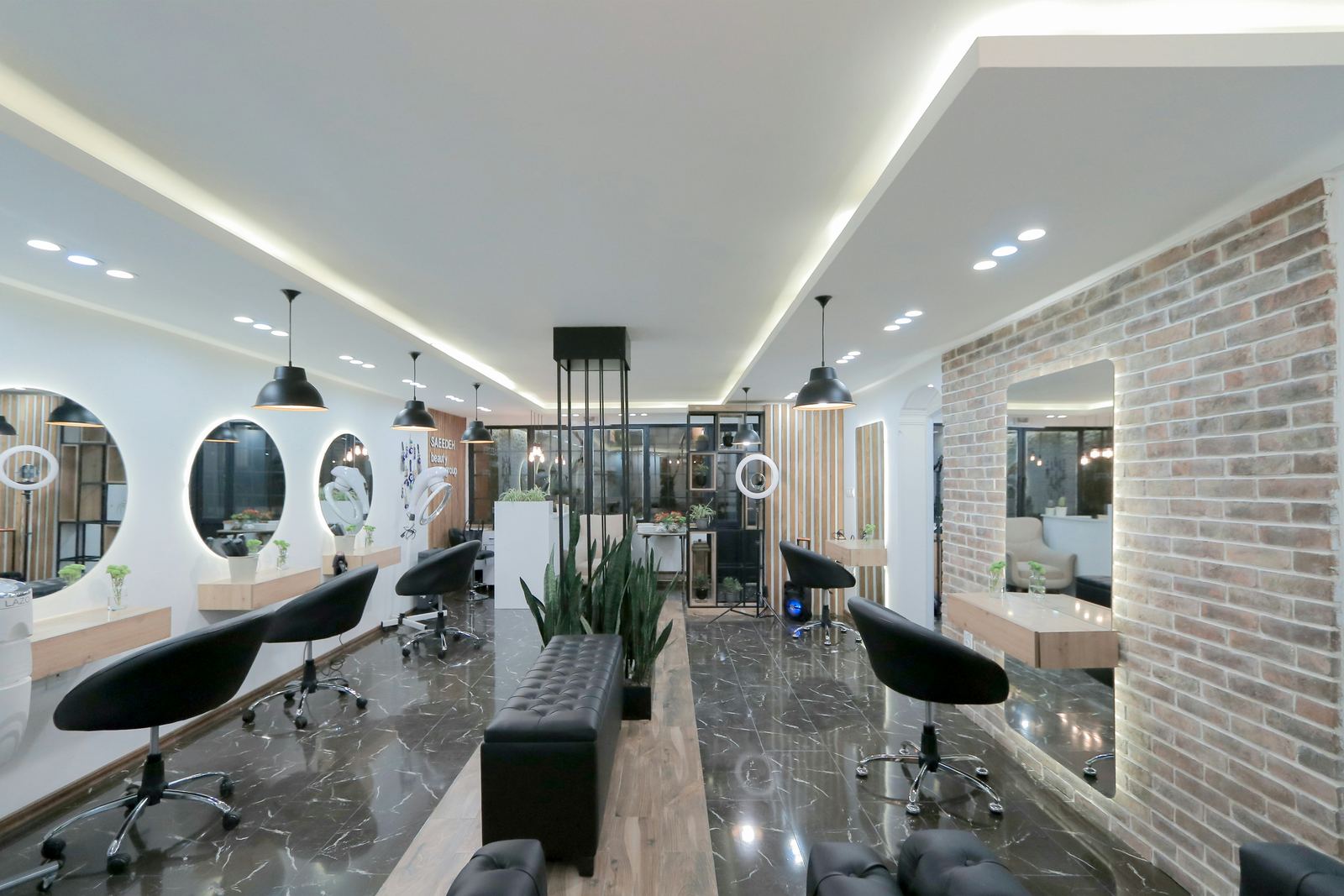 A long hair salon floor with styling stations and a brick wall
